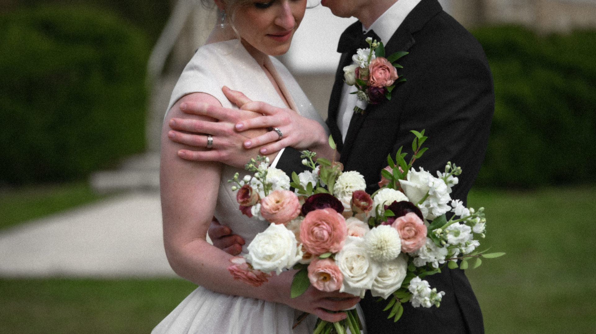 wedding couple in black tie and gown showcasing bouquet