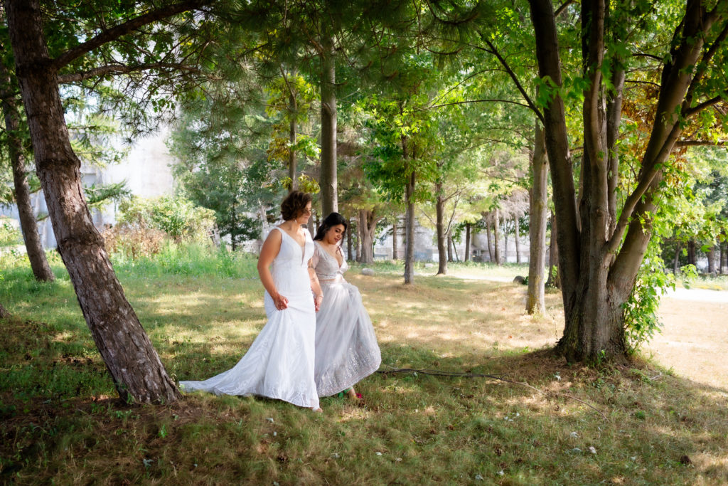 bride and bride walking in woods photo