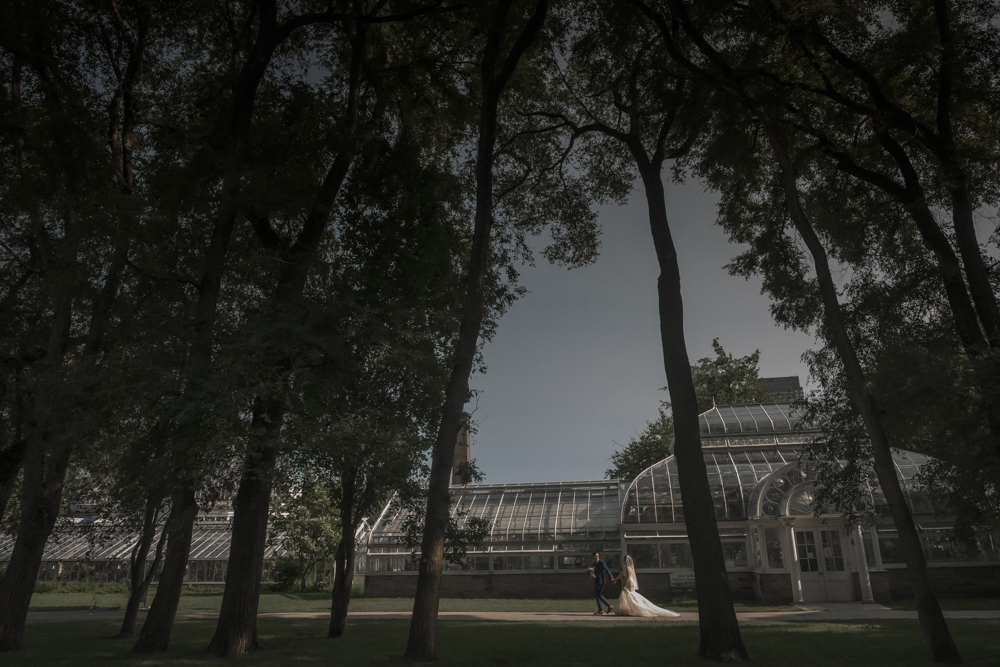 wedding couple walking with glass tent in background