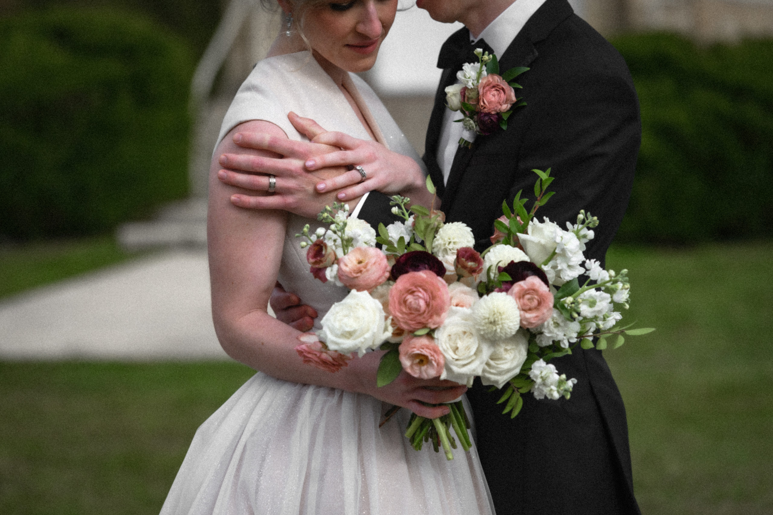 wedding couple in black tie and gown showcasing bouquet
