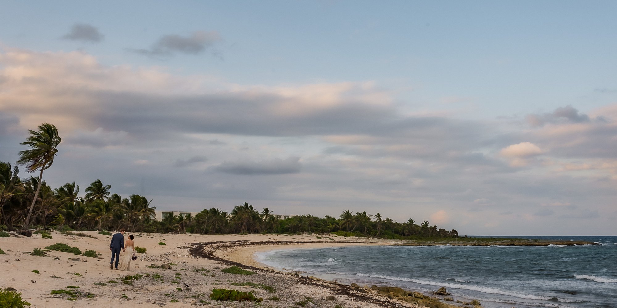 bride groom walking on beach in mexico