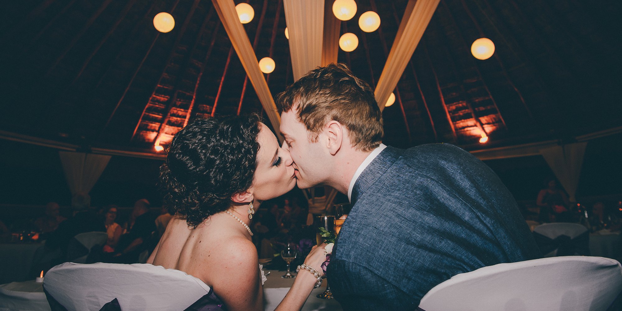 bride groom kiss at head table