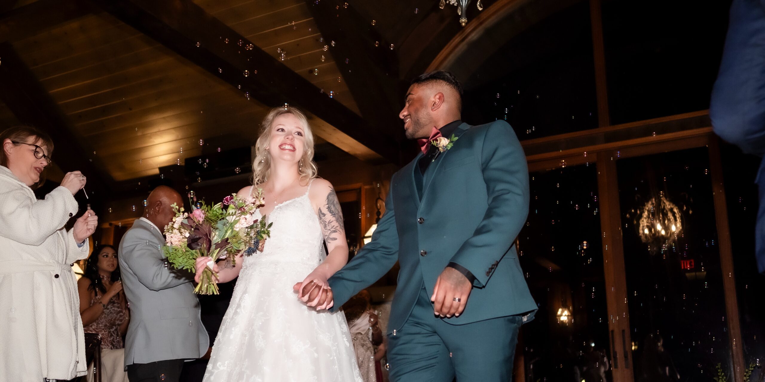 groom in green suit escorts bride during ceremony exit