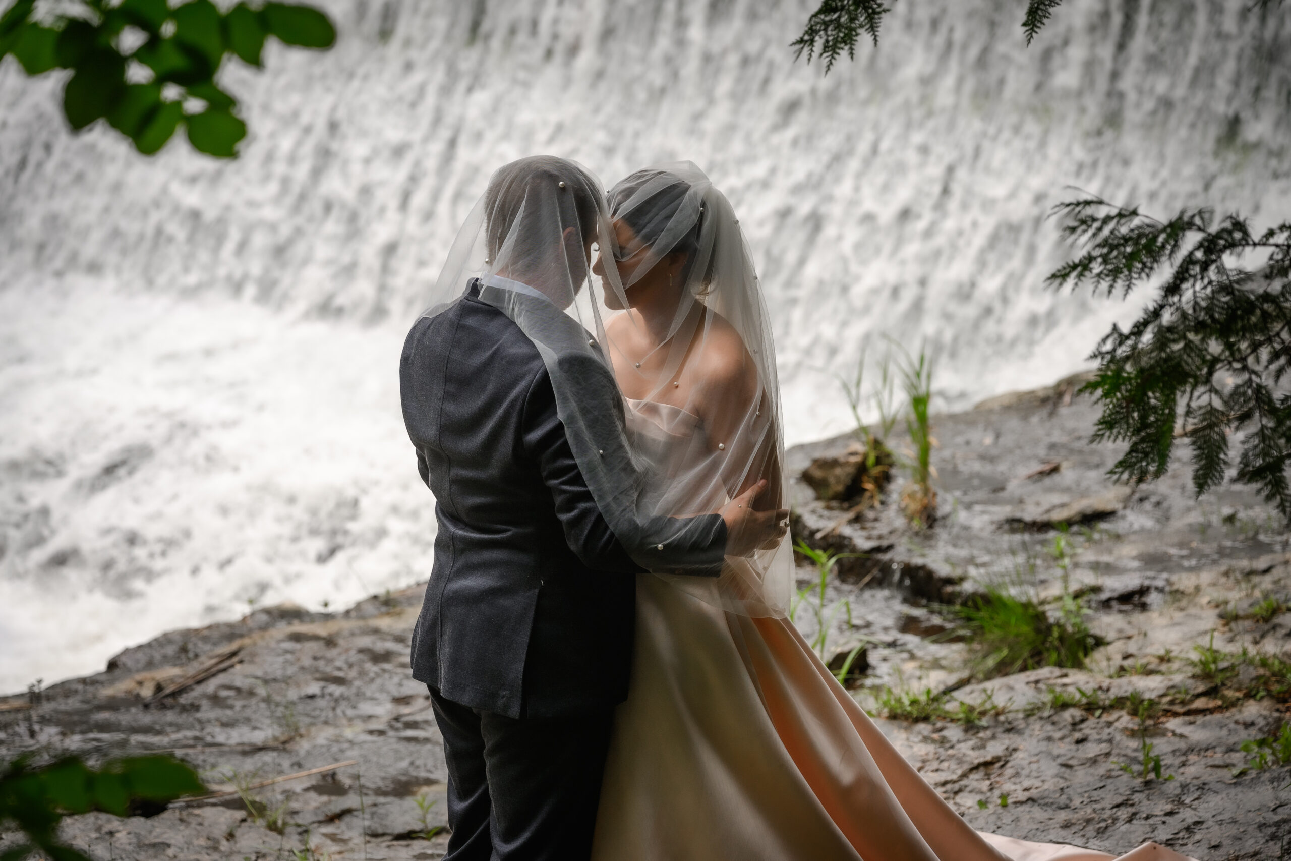 bride groom under veil at waterfall in Alton