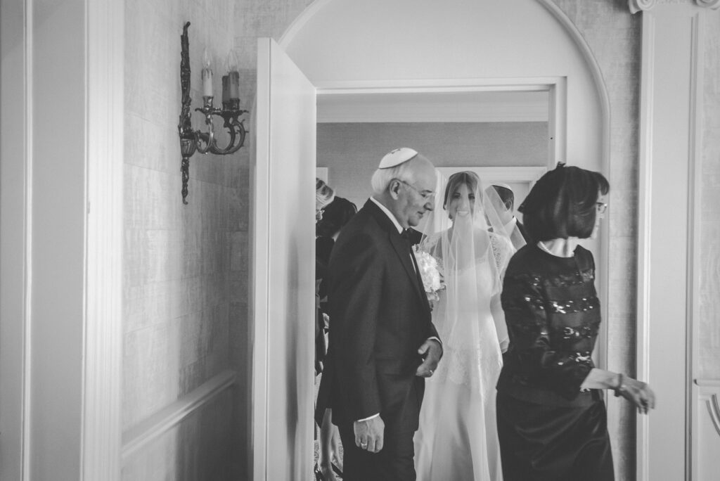 father escorts bride down the stairs for ceremony