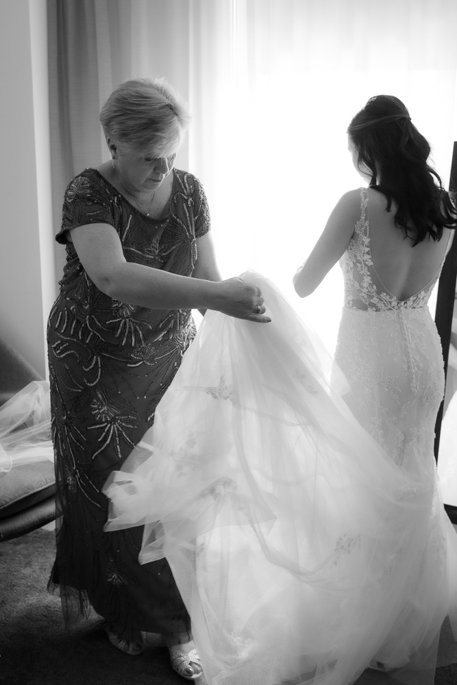 mom helping bride with wedding gown at Walper Hotel