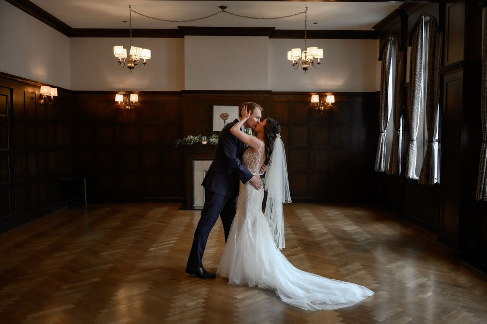 Wedding Couple Kissing in Oak Room at Walper Hotel